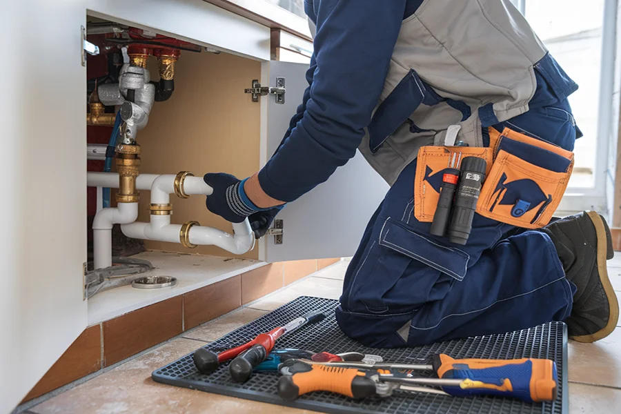 Alex from Johnson Plumbing cleaning a sink drain in Asheville, NC Johnson Plumbing Asheville NC drain cleaning